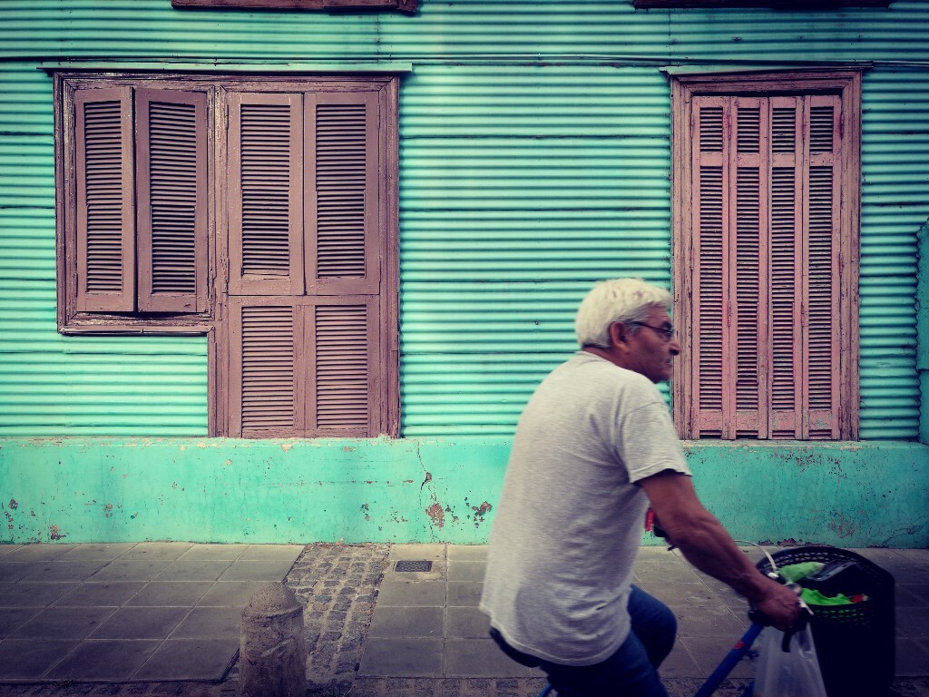 一位老人骑自行车路过博卡区。