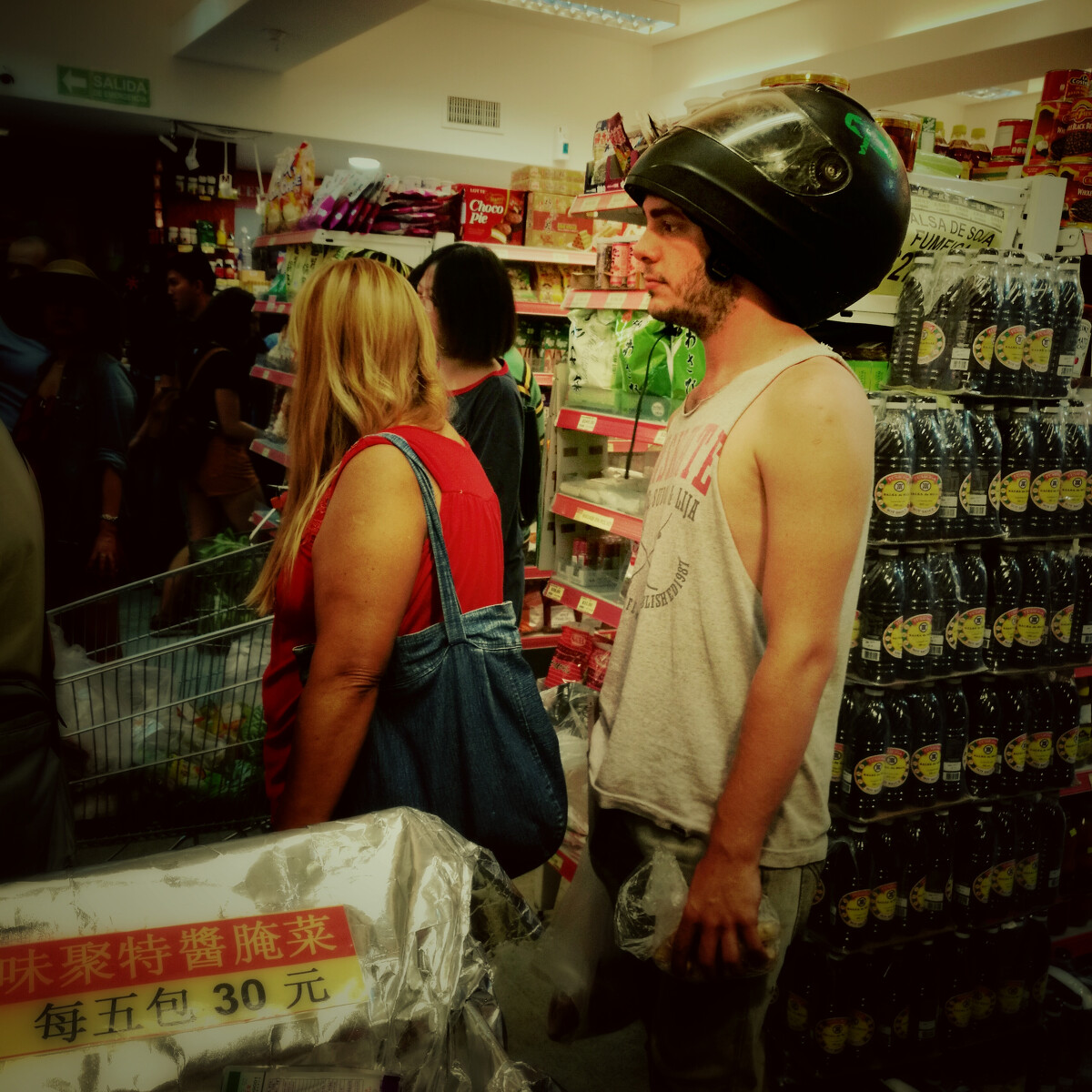 当地一家中国超市里的男子戴着摩托车头盔。