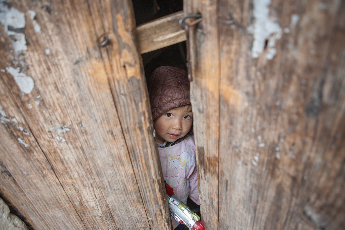 小朋友在家门口玩耍,看见我这个陌生人走进他,立刻跑进家里插上了门栓