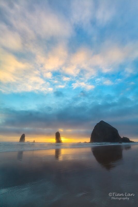 Cannon Beach Sunset<br />
很幸运能够在海天连线的地方得到一丝空隙。落日的光线从缝隙里透出来，头顶上的云被映得发亮发红。