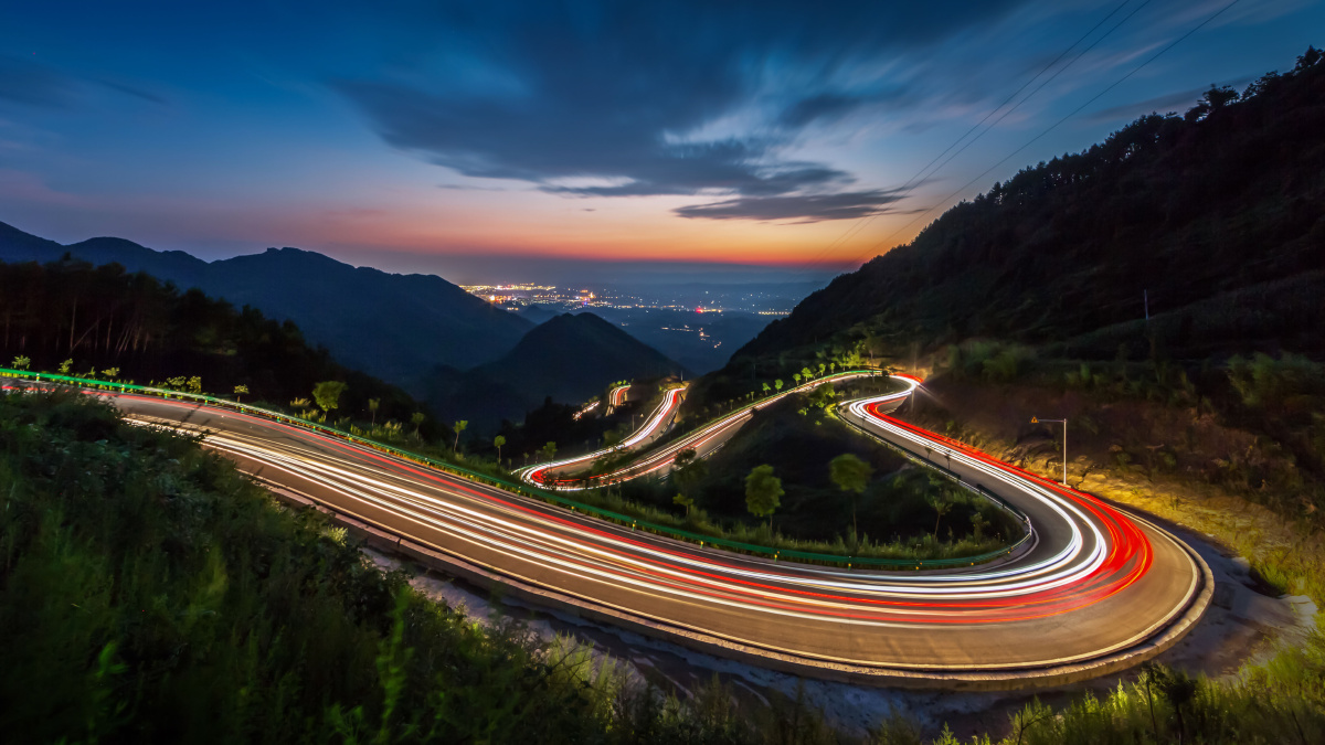 车辆行驶在山间蜿蜒的山路上,车轨拖出了一个心形,连接着