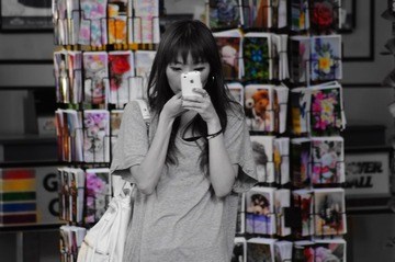 路边 照Iphone 的女孩