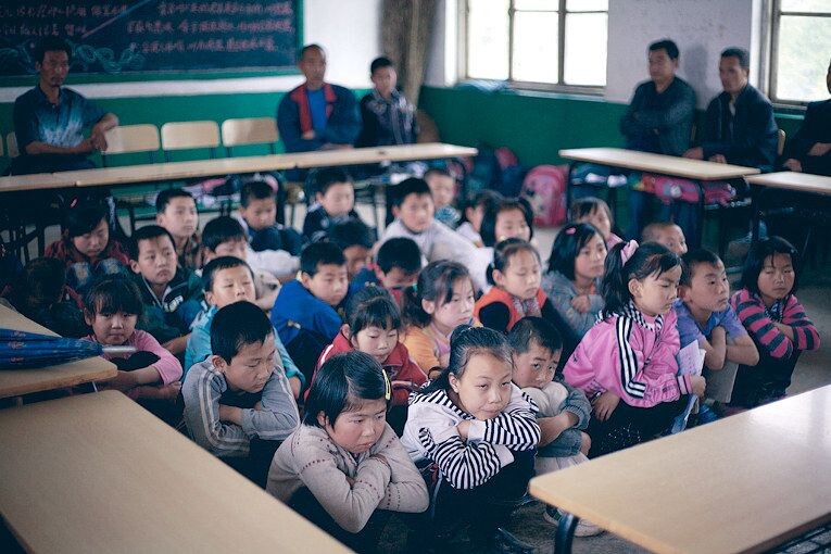 三年级的教室里,班主任似乎有点严厉。学生们被要求蹲在地上接受点评,家长到的也不齐…….大家都一脸无奈
