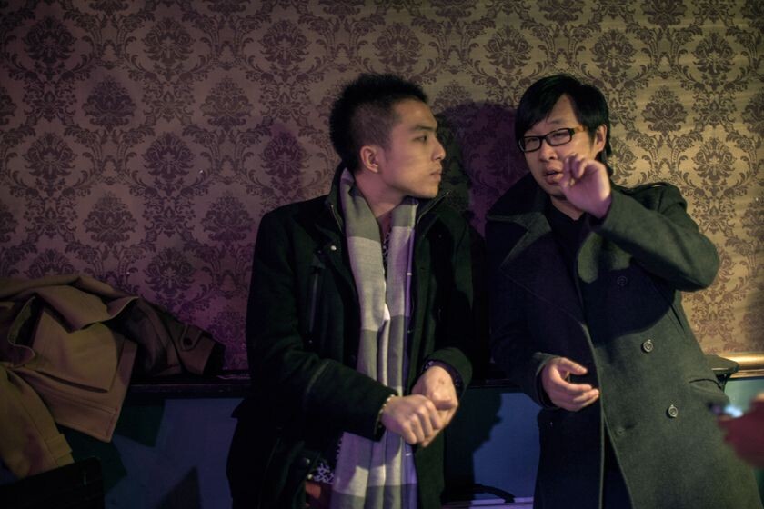 21<br />
罗贝和栗东放好乐器，站在场地的一边等待livehouse的工作人员调试灯光和音效。