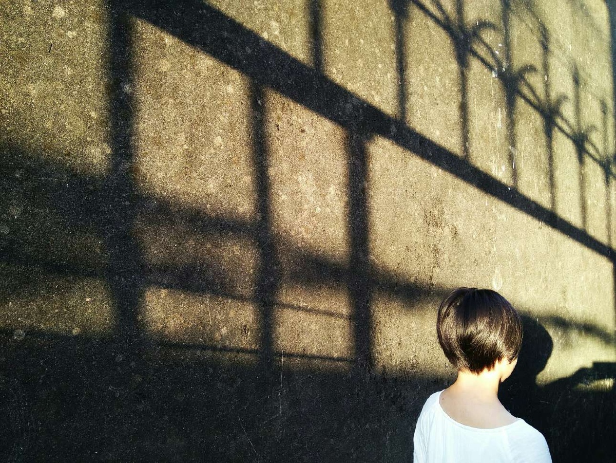 游古寨,经过一道铁门,开门让女儿进去,阳光从墙上折射出的光影