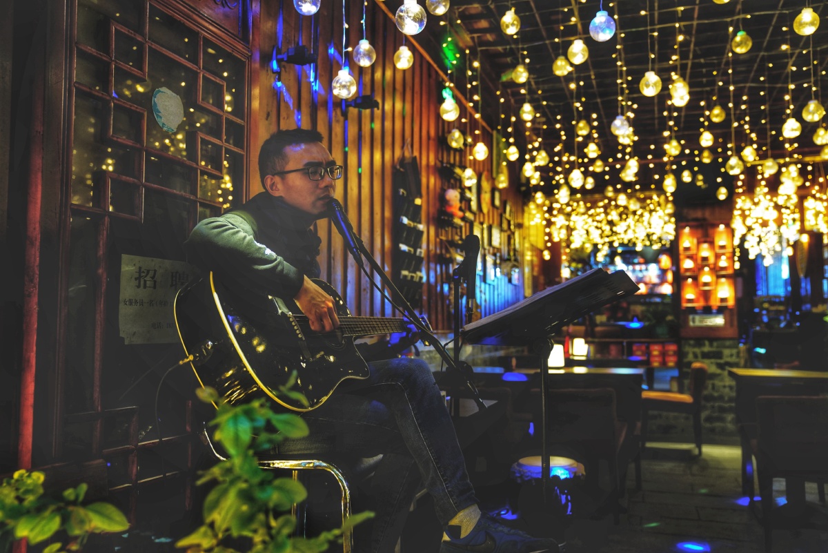 酒吧的门口,带着眼镜的吉他手自弹自唱着郑智化的水手,声音里面满满的