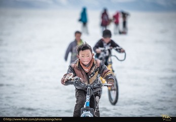 纳木错冰湖上骑车的藏族小孩