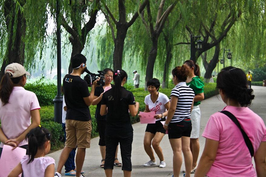 济南印象<br />
大明湖畔，几位白领人士在做蹲瓜游戏。