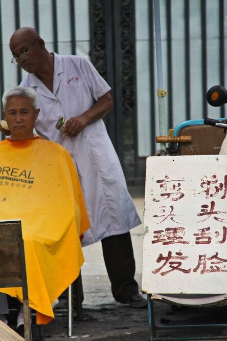 济南印象<br />
大明湖畔，一位街头理发师正在为市民理发。像这样的街头剃头摊儿基本少见！
