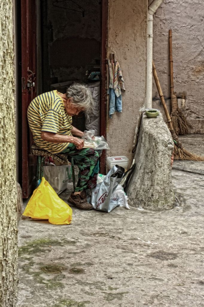上海人以前喜欢在炎夏搬着板凳，躺椅到弄堂口，三五成群地聊天喝茶乘风凉，男女老少形成了独具一格的人情世态，现在这样的风景已经不常见了，偶然看到也是老一辈人家。