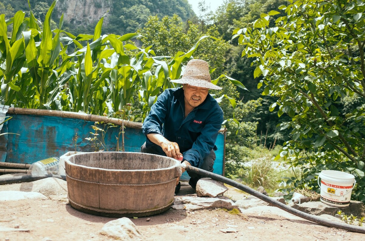 安全饮水改造后，水管直接到了家门口，图为一农户在家门口洗东西