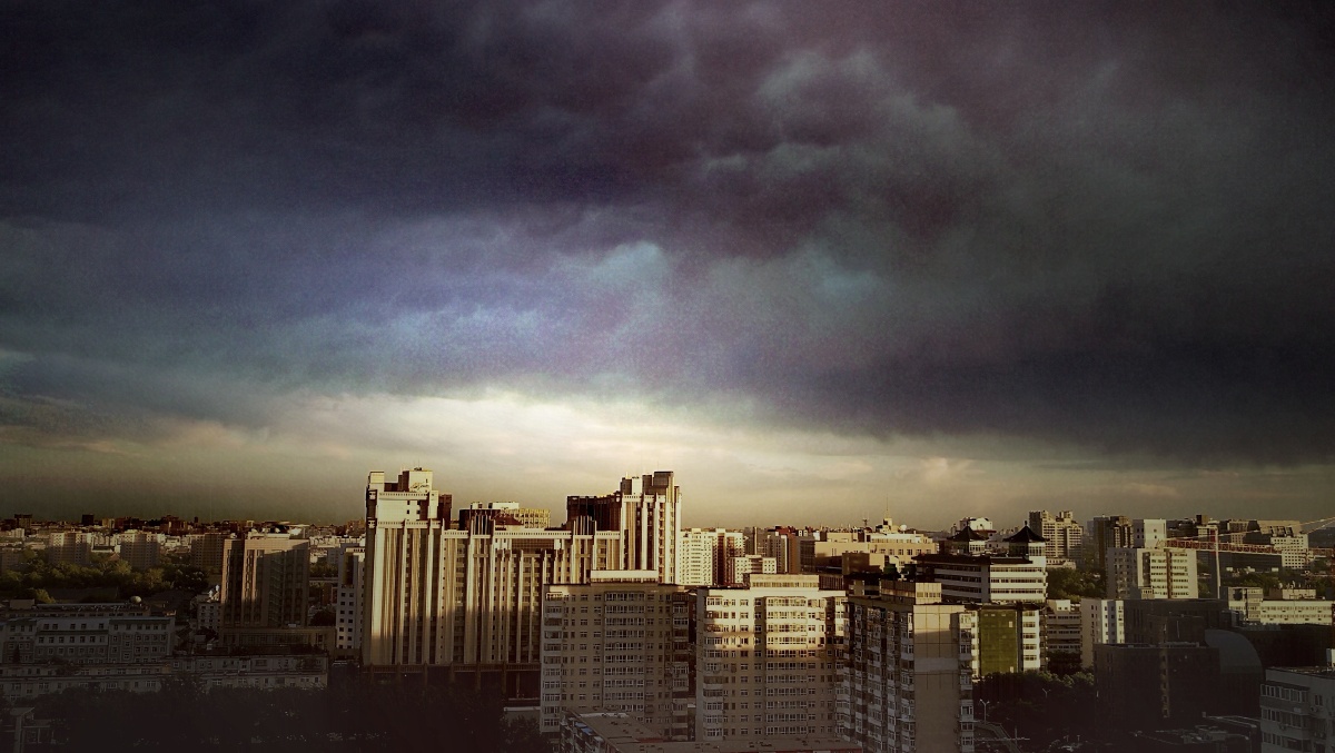 忽然阳光透过乌云,照亮城市,乌云与阳光同现天空,显现出奇观 - 湘水