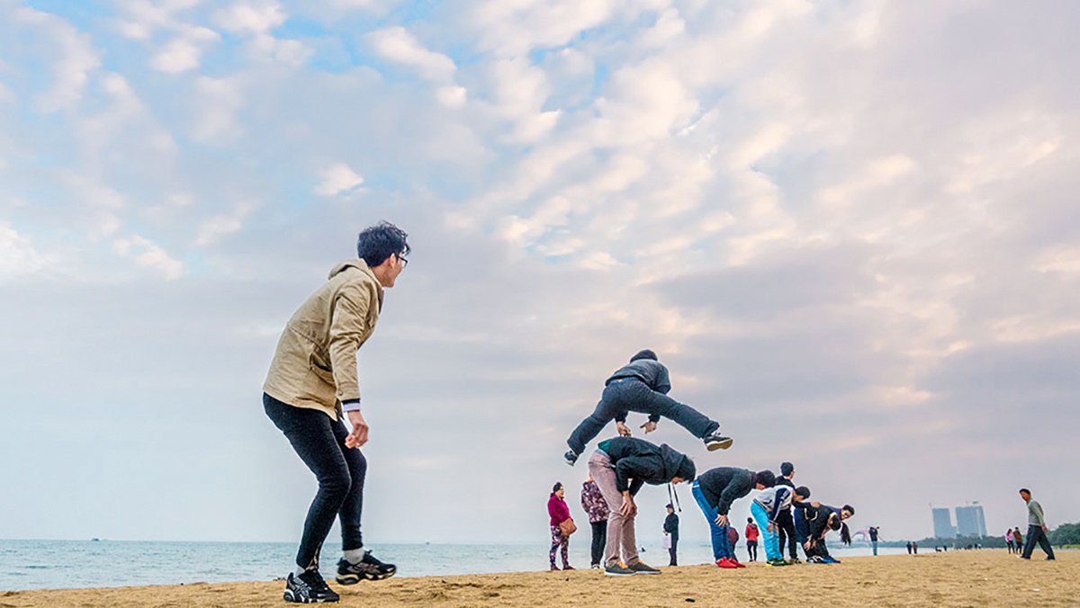 一群年轻人在海边沙滩上玩儿时的游戏,热情奔放充满青春活力