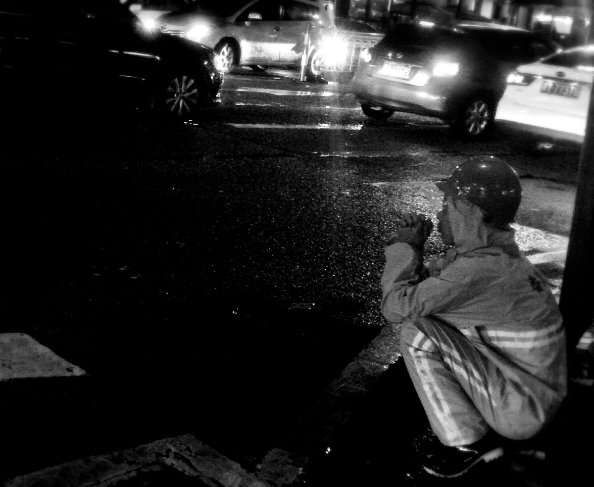 夜晚蹲在路边的环卫工人