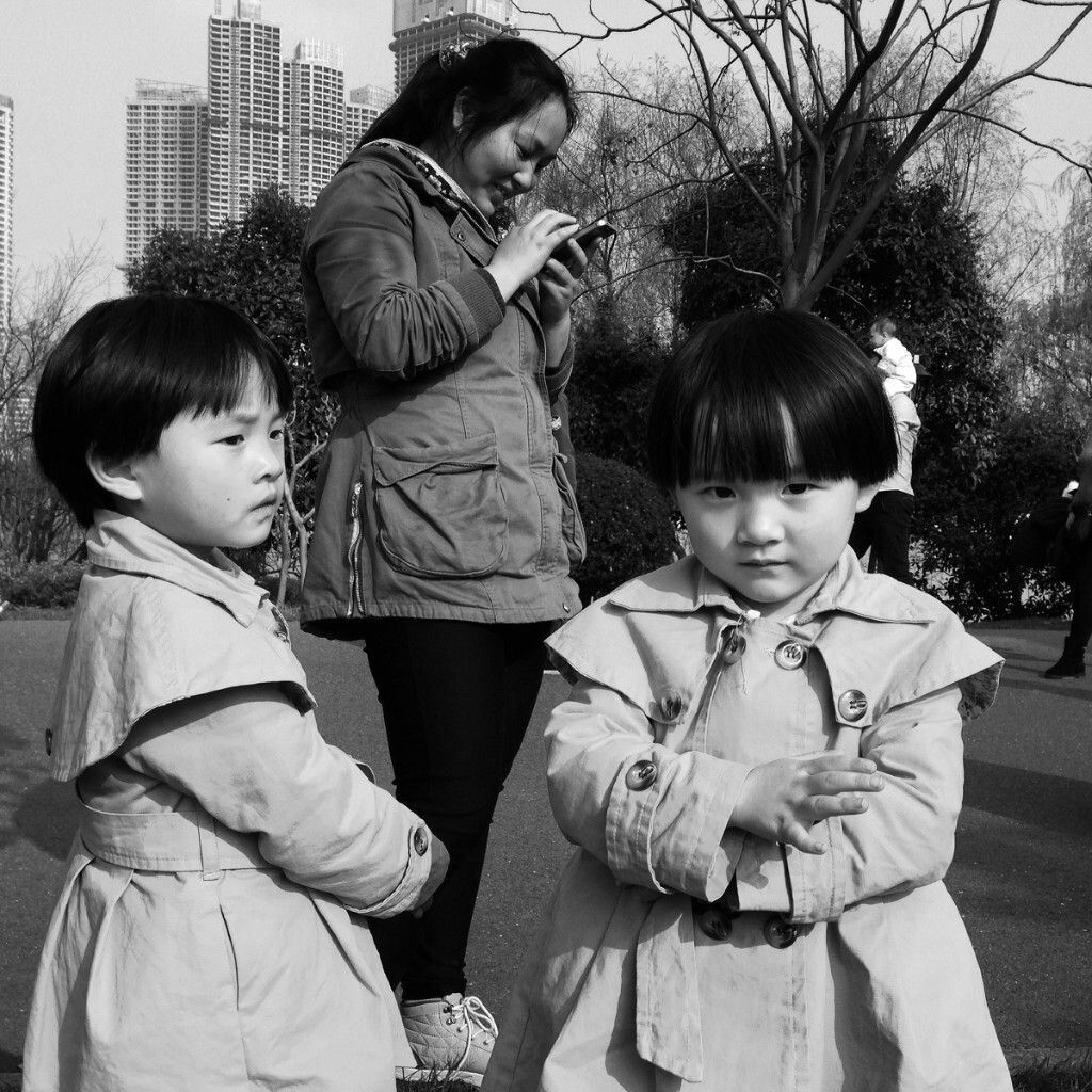        2015年3月21日，长沙市橘子洲头，双胞胎姐妹和她们玩手机的妈妈。