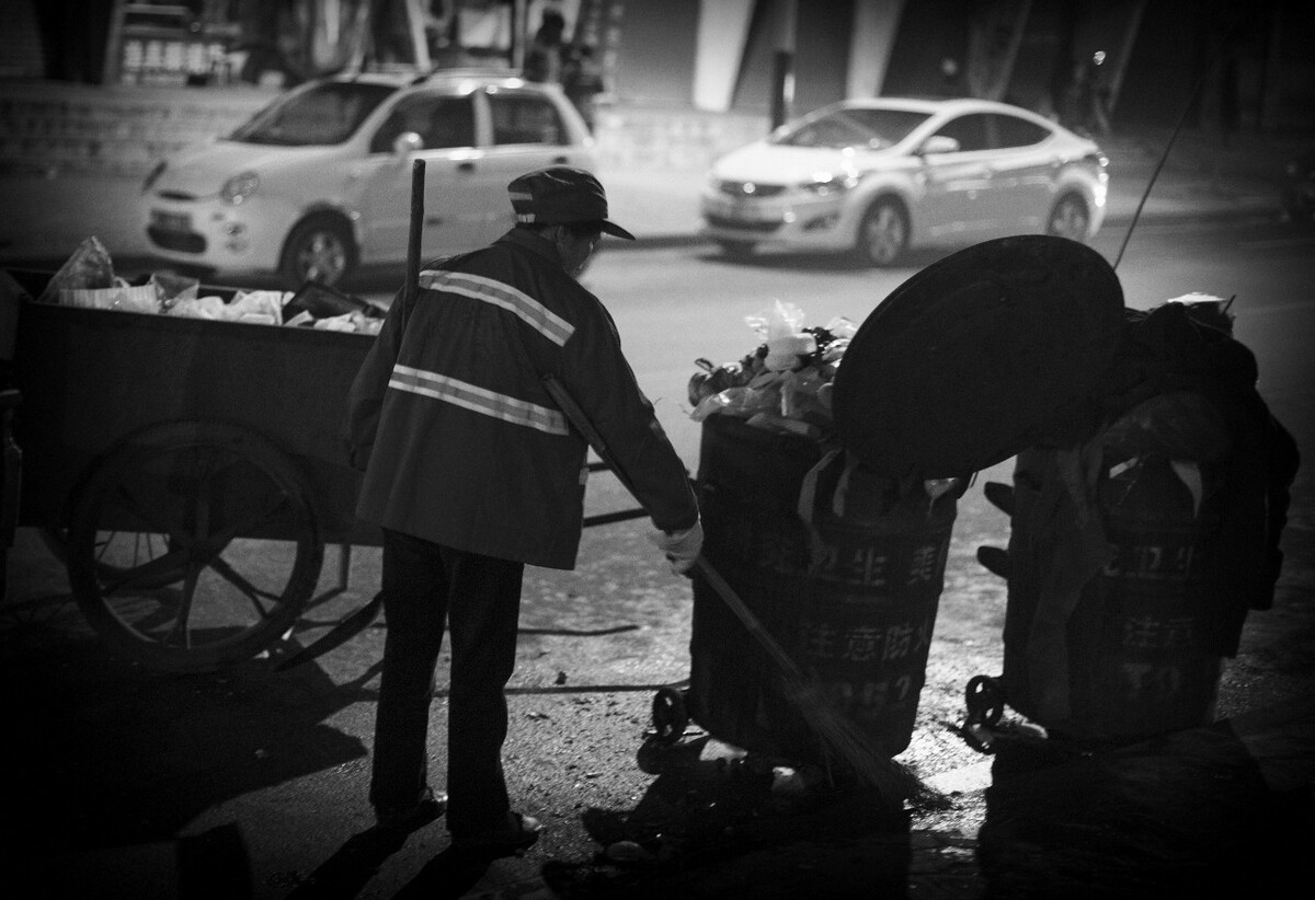 大年29晚上20点，一名清洁工在清洁小镇的街道。父亲说：“他们多来自乡下，工资很低，工作时间却很长，很累。“