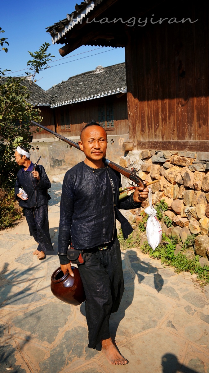 岜沙的苗族汉子正在赶往他所在的表演场地