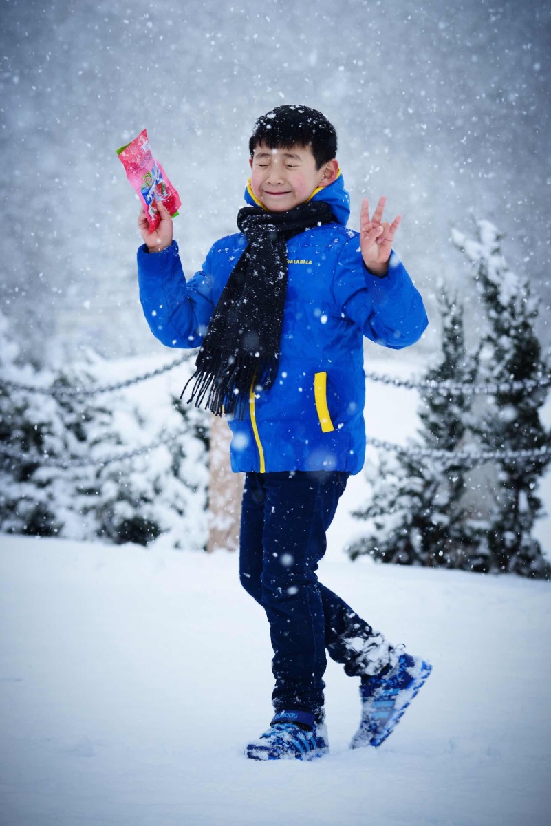 山东威海荣成烟墩角,一小男孩陶醉在漫天纷飞的大雪中