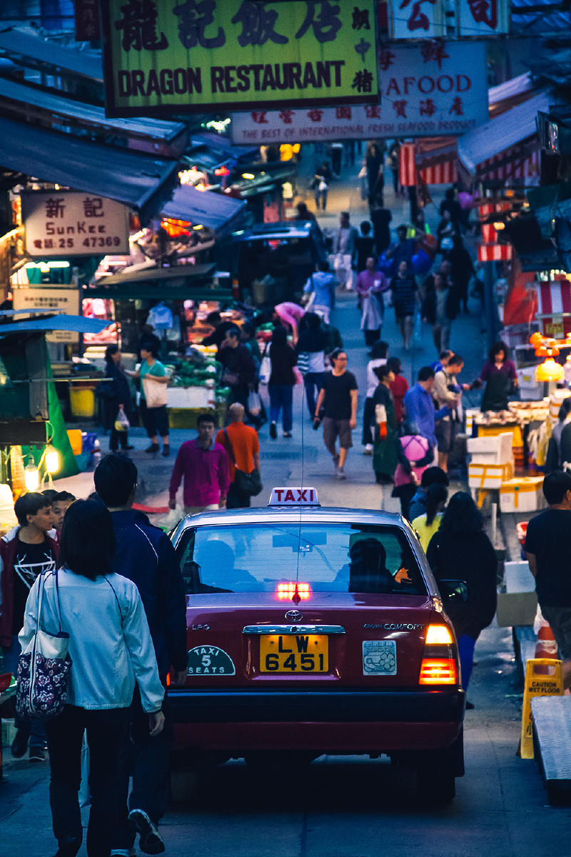 > 印象中的香港,一个集市,上面是许多很有特点的招牌,路上行人许多