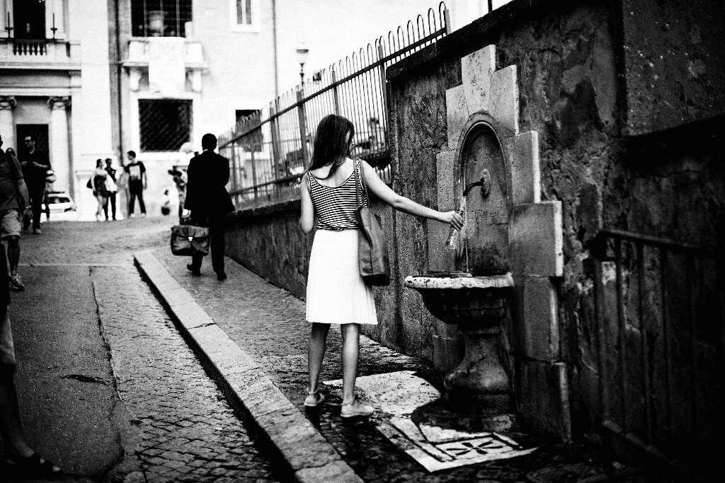 A girl refilling water bottle 街头灌水的女孩
