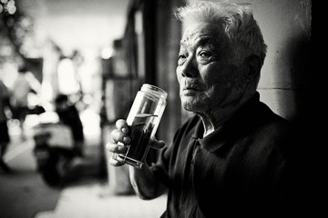 An old man with tea bottle