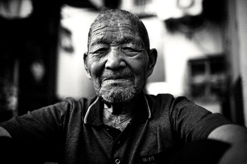 A portrait of an old man sitting in a chair