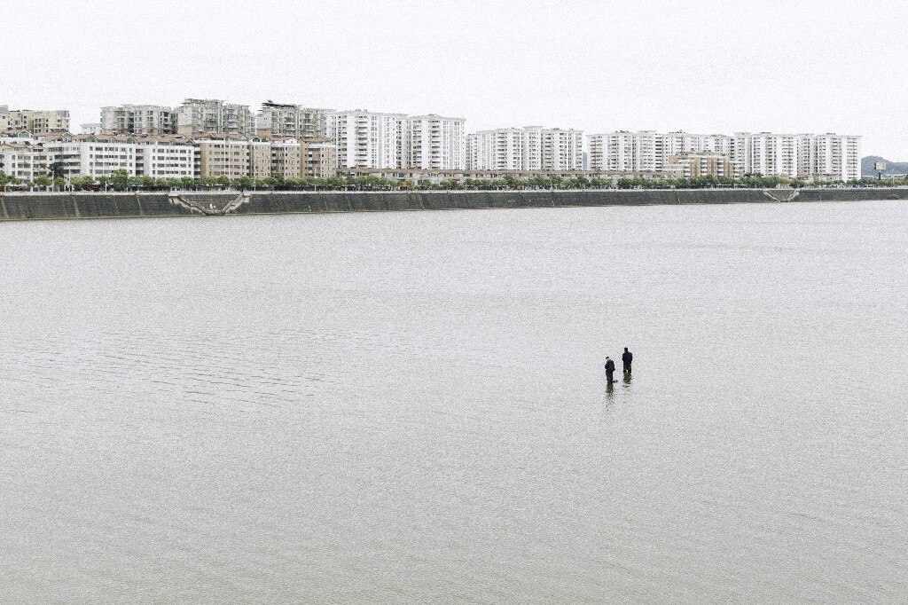 水位低时,钓鱼人会结伴穿着肥大的防水裤,走到江面中央钓鱼。