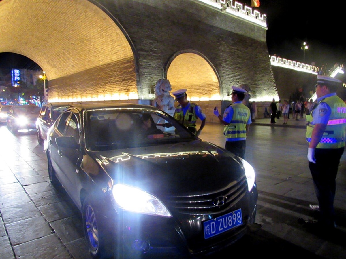 交警在古城墙下查处酒驾违法行为。