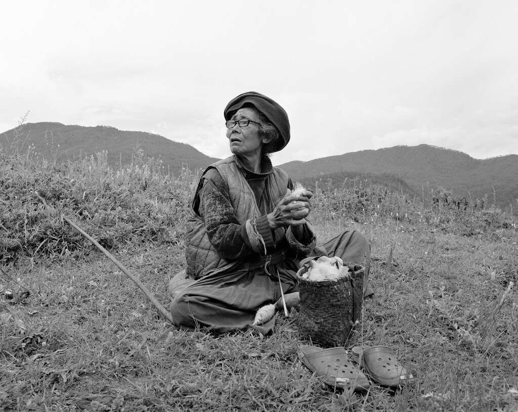 摩梭阿妈在放牧的闲暇中用线锤纺线。