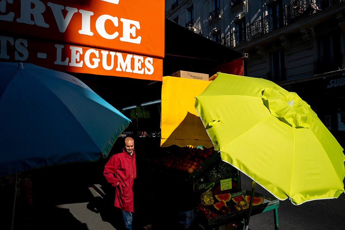 2020年5月，法国巴黎。<br />
街头的蔬果店，色彩各异的店员、遮阳伞和蓬幔。