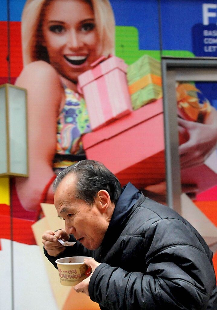 腊八<br />
2012年1月1日,一名郑州市民边走边品尝刚免费领到的“腊八粥”。农历的腊月初八,我国大部分地区都有喝“腊八粥”的习俗。在中原地区,除了预祝来年五谷丰登的寓意外,腊八粥还被称为“大家饭”,是纪念民族英雄岳飞的一种节日食俗。<br />