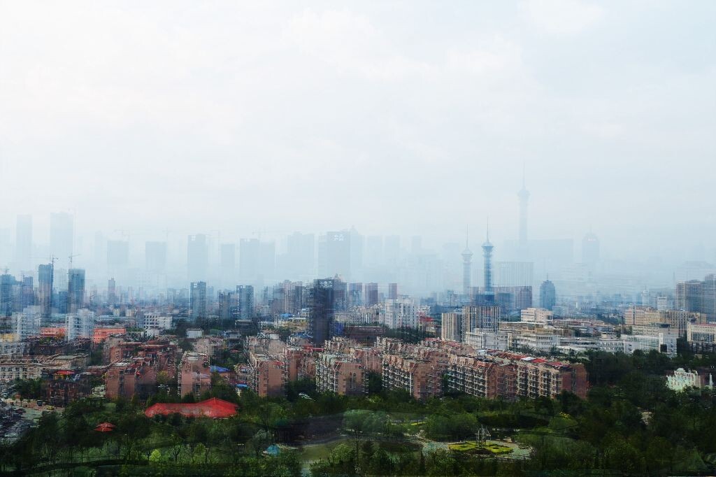 多张不同季节不同天气不同时间拍摄的照片在PS里叠加，想表现的是“城市中高楼大厦飞速建设，形成钢筋水泥的丛林，而留给居民分享的绿色空间却越来越少。