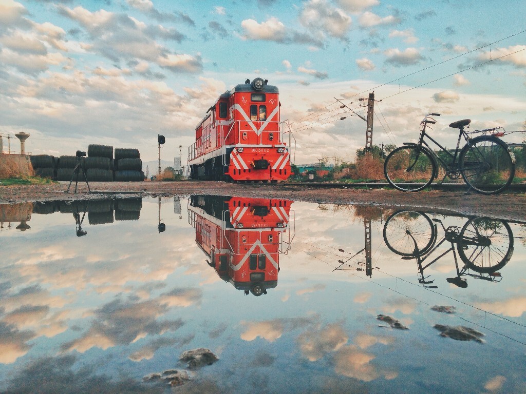今年手机摄影也没停下，雨后的北京晨曦，彩云、火车头、倒影和自行车，还有我正在拍延时的相机