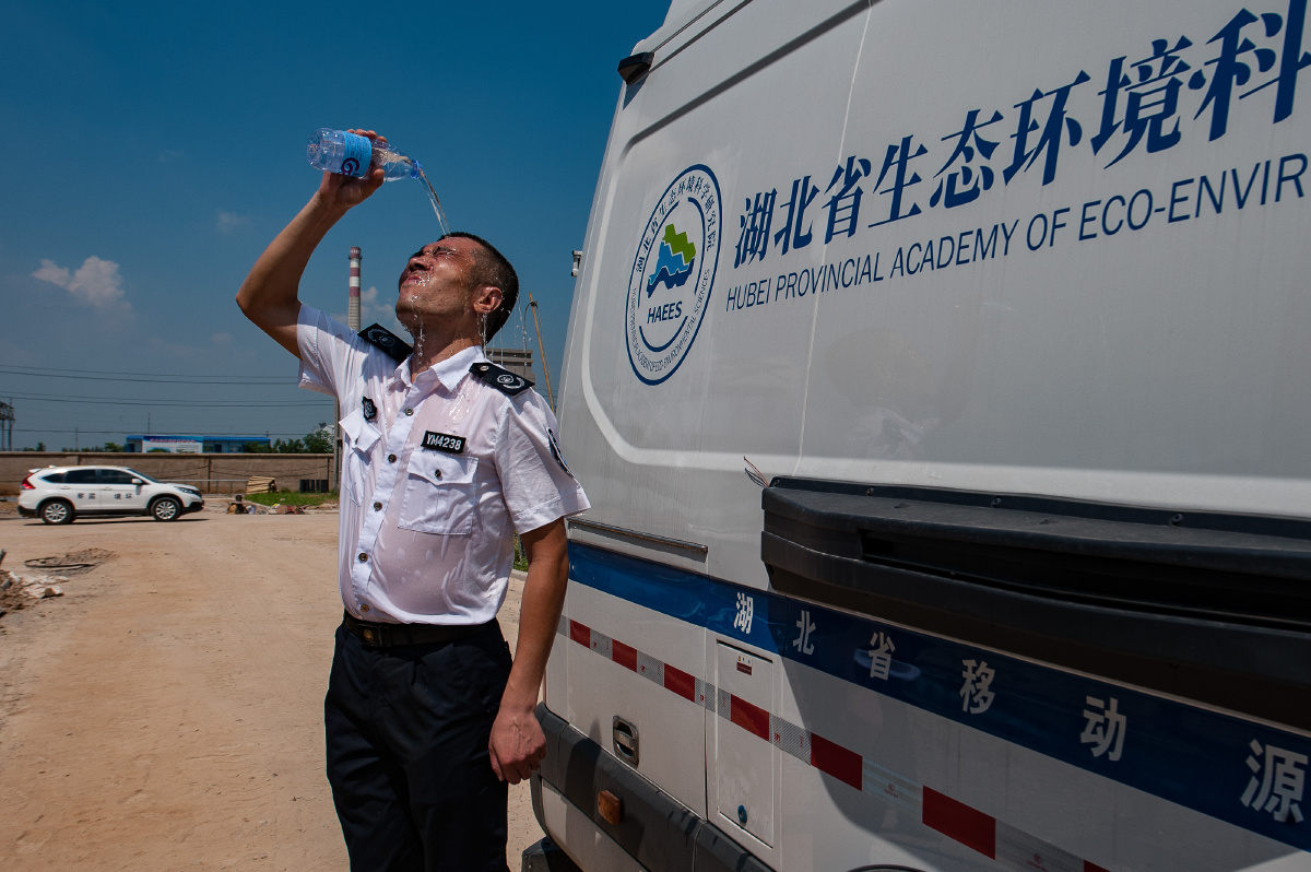 环保监测工作人员顶着酷暑在工地上检查粉尘.