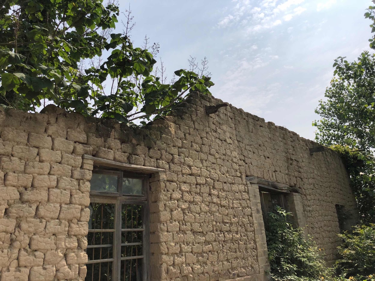 整个房子墙体是由一块块泥砖砌成,却很结实,屋顶没了,墙体还