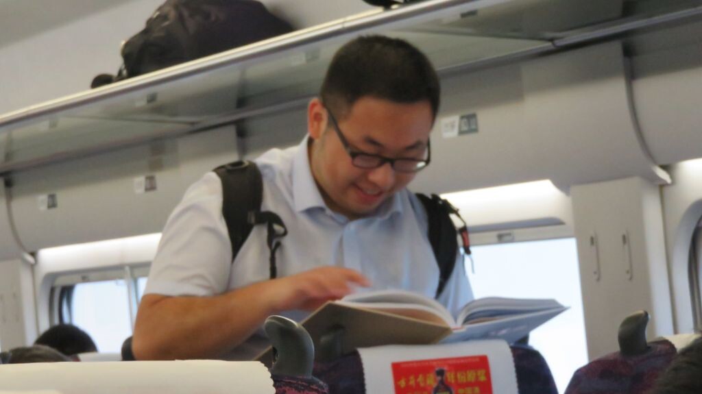始发车每个座位都发放了开通纪念册。图为小伙伴在研究