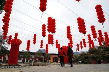 2018年2月16日，正月初一，广西融水苗族自治县城郊一个农场，游客在红灯笼中游玩。2