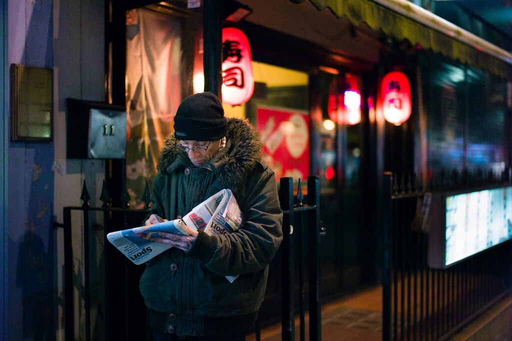在餐厅外面玩每份报纸上填字游戏的人