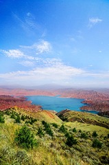 坎布拉森林公园中李家峡水电站的水库，在呈红色的丹霞山的环绕下显得给外湛蓝