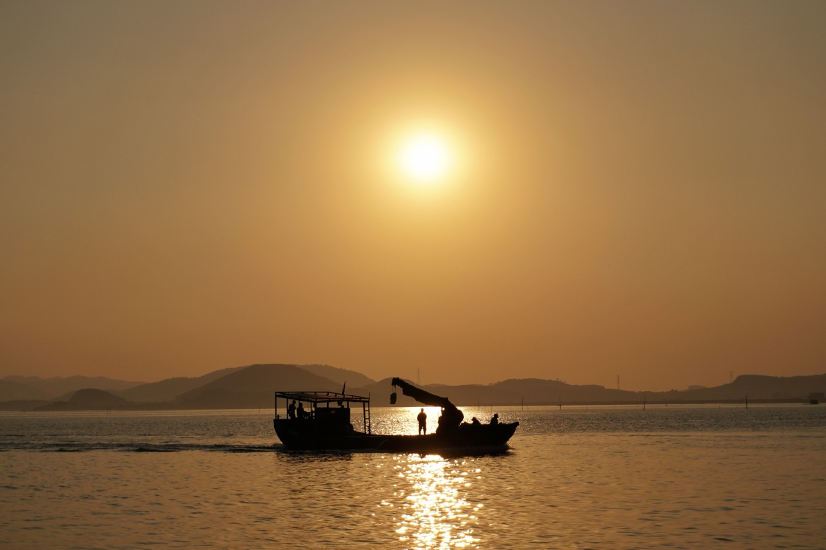 夕阳下的海上渔船