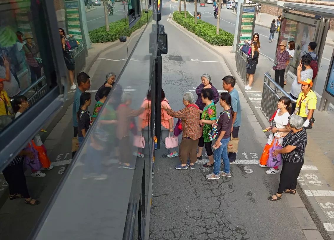 公交车站台人们有秩序的上车,双层公交车上拍摄