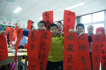 金海岸小学的小学生展示自己寒假写的对联.JPG