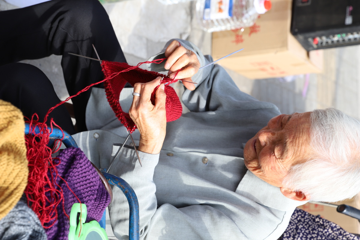 当我举起相机时,这位老奶奶面带微笑却未曾停下手中的活.