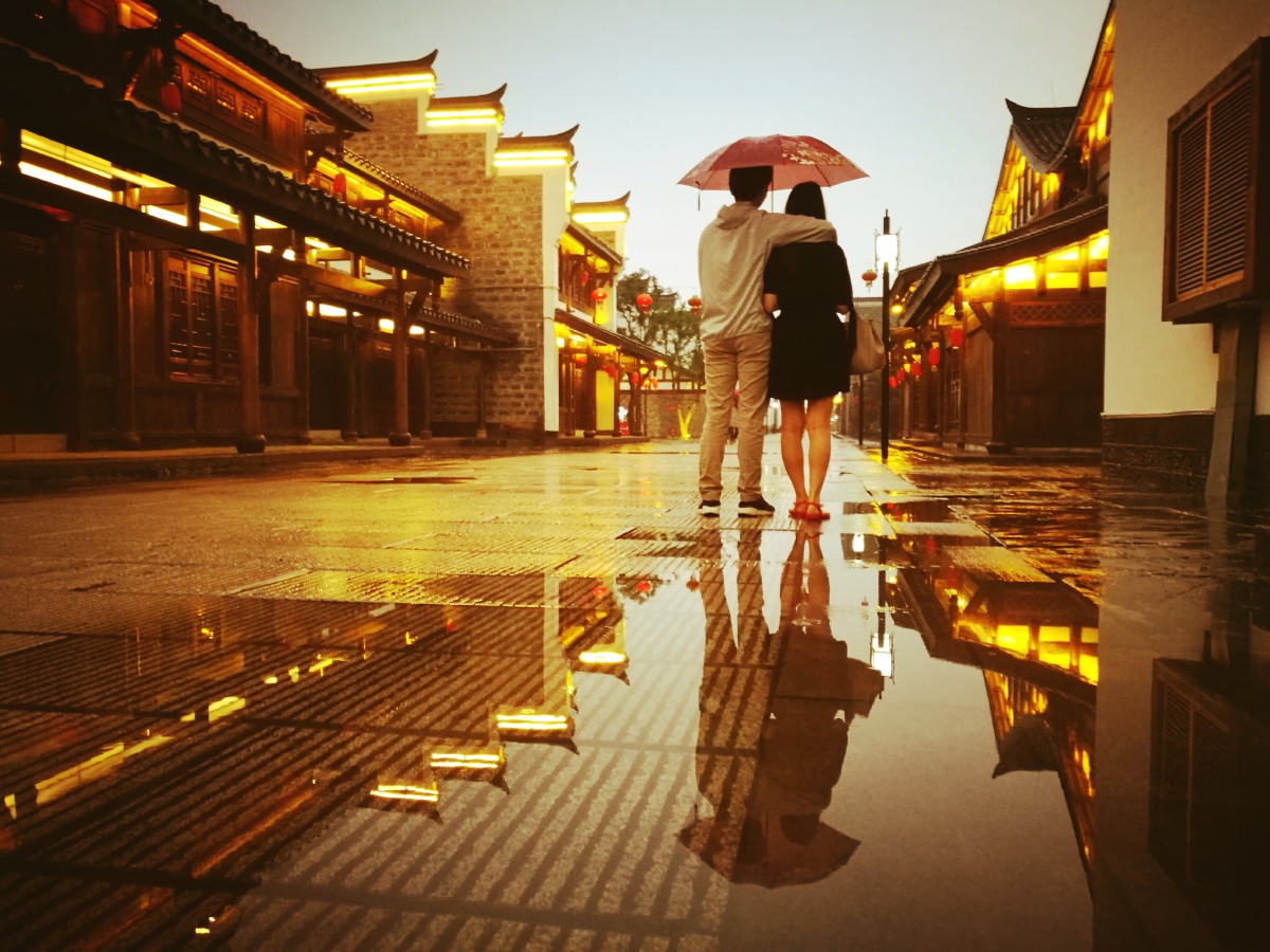 男孩一手轻揽玉颈,一手为女孩遮风避雨,呢喃轻语,耳鬓厮磨,此情此景