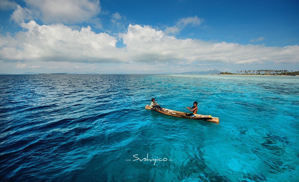 马来西亚仙本那，快到pulan maiga麦加岛的时候，在近海抓鱼的巴夭族两兄弟，海水在这里由浅变深，因此海面呈现出漂亮的颜色过渡。