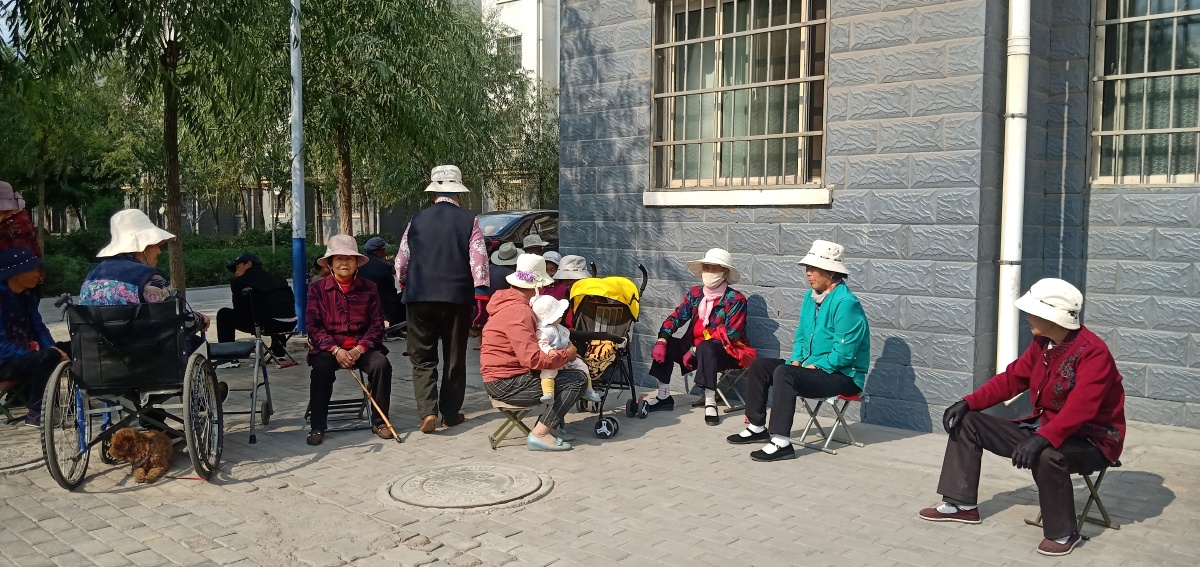 怎么说呢今天来拍摄移民村看到这个社区的老年人一波一波的坐在楼底下
