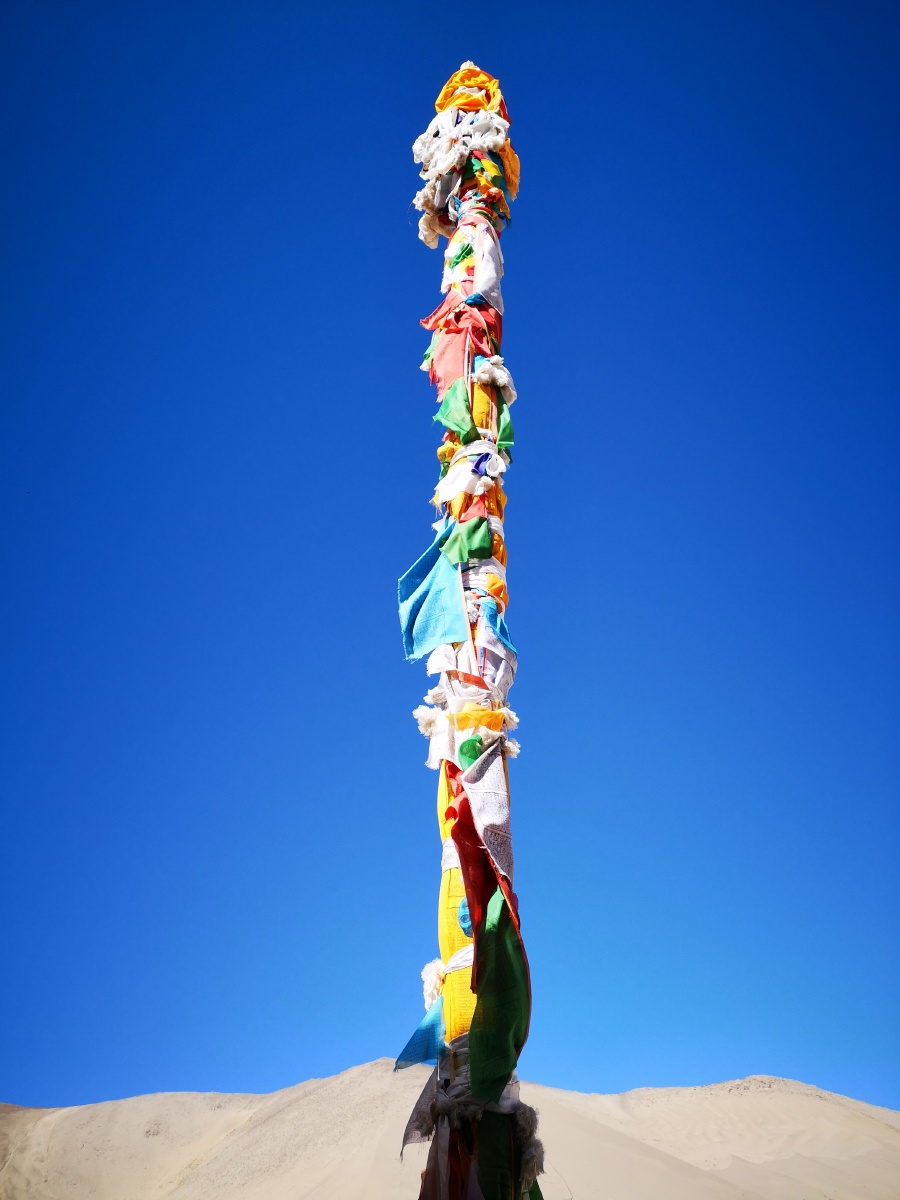在四月的高原蓝下,平措林寺的经幡柱和寺庙的红墙.