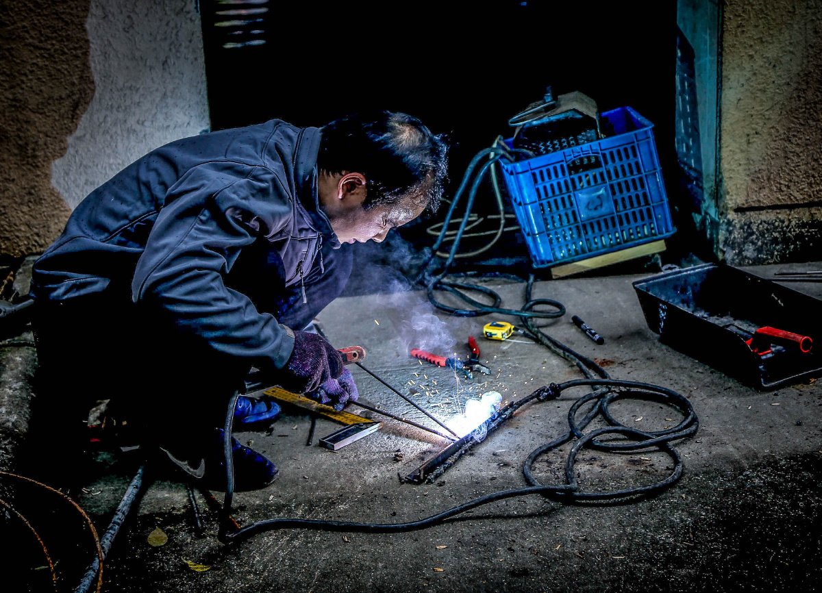 街角边专注工作的电焊工