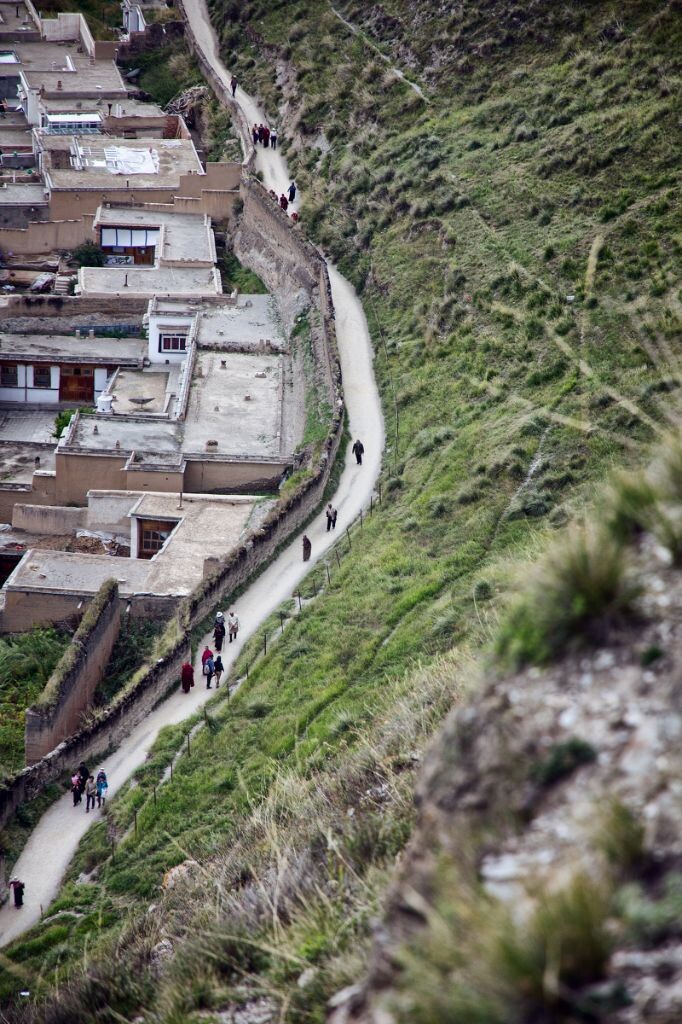 登上夏河县旁边的一座山，俯瞰拉卜楞寺南侧的一条小路。