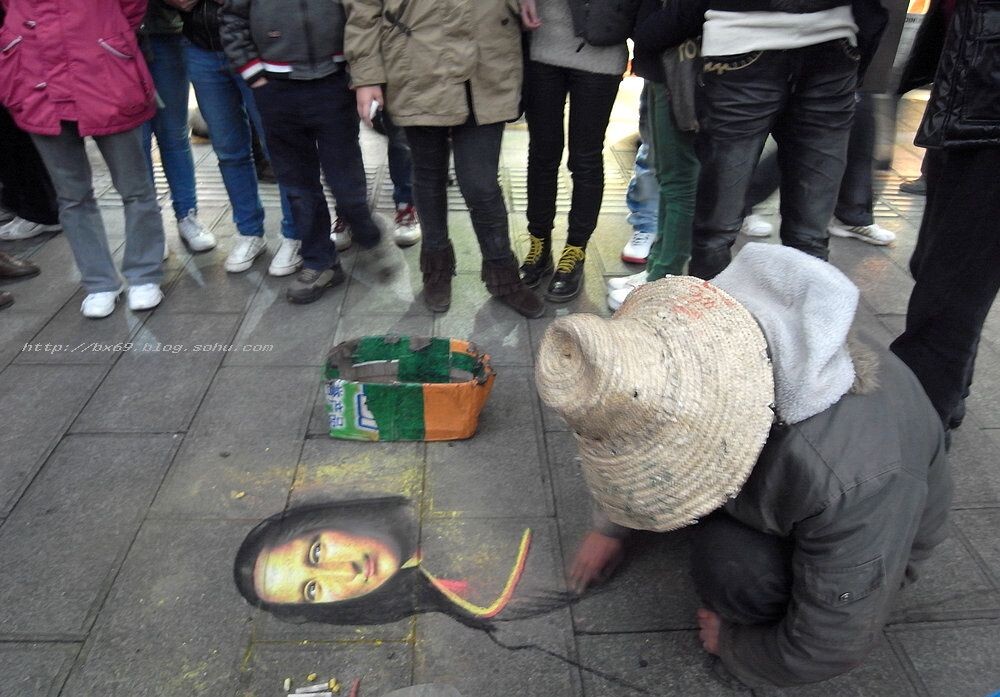 11.24.重庆沙坪坝街头,一乞讨者用粉笔在地上画出蒙娜丽莎的微笑.